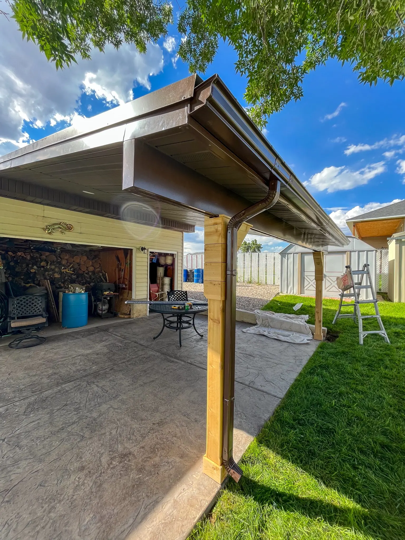 Timber patio roof with decorative braces beside a house