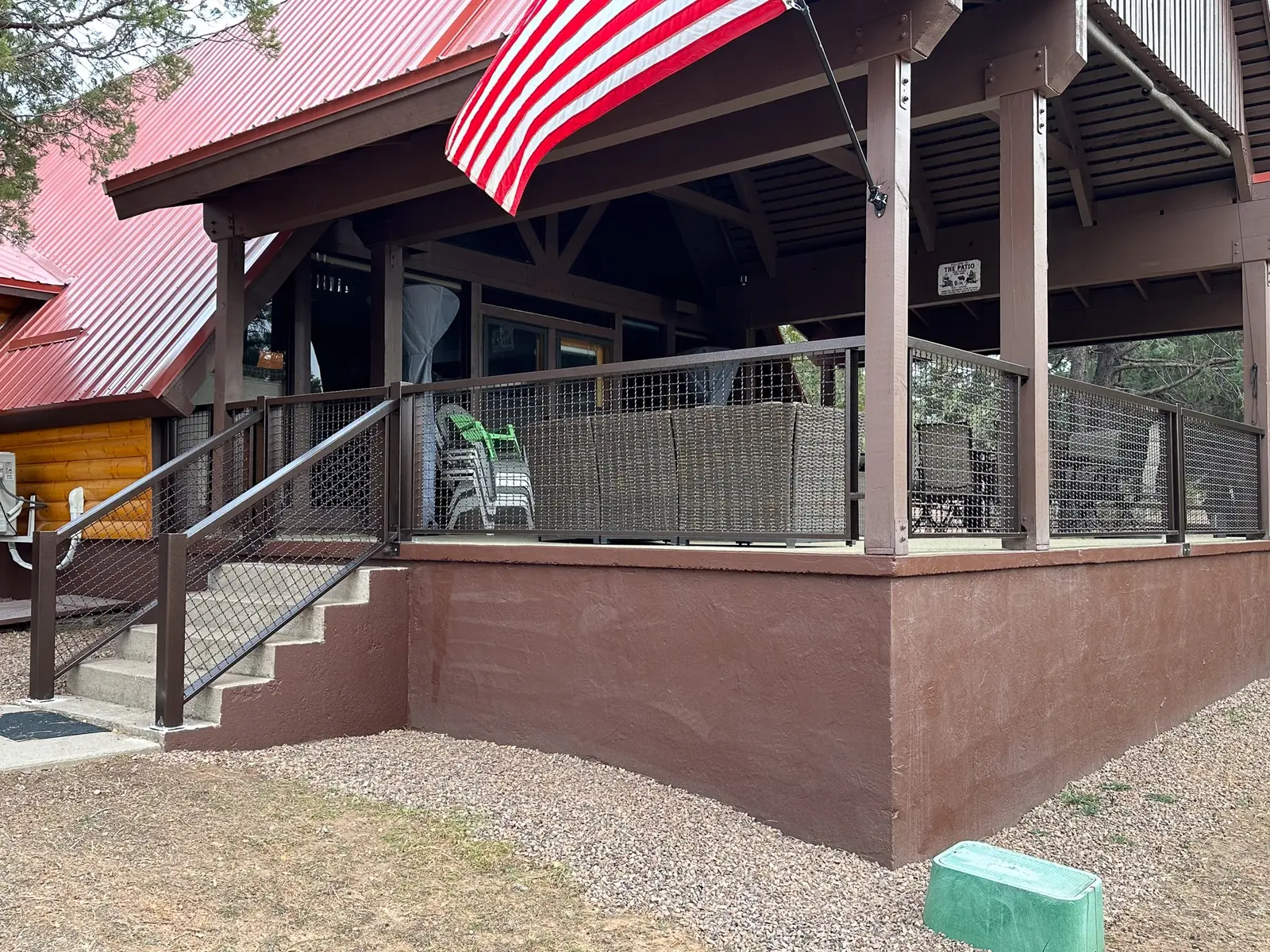 Roofed timber outdoor structure with mesh panels and an American flag